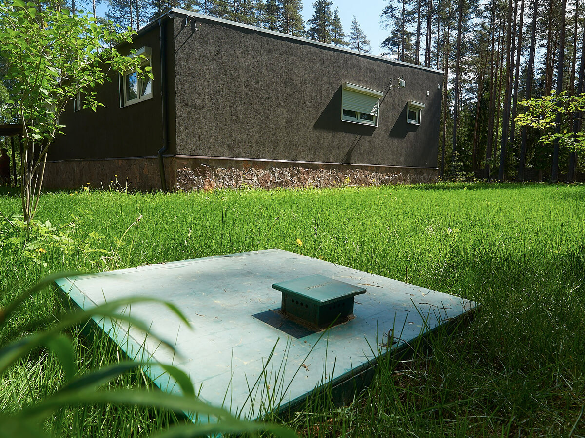 Крышка септика на участке рядом с домом