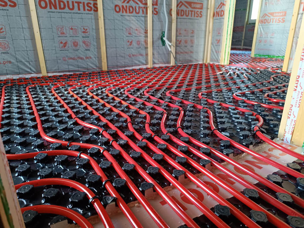 Монтаж тёплого пола с красными трубами отопления в помещении